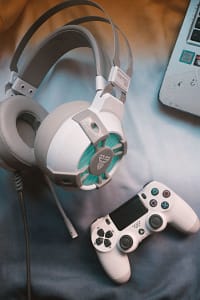 Audífonos y control de videojuegos sobre una mesa, imagen referencial de sonido para videojuegos